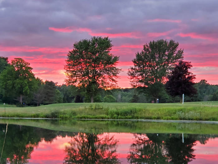 Golf course with trees at sunset